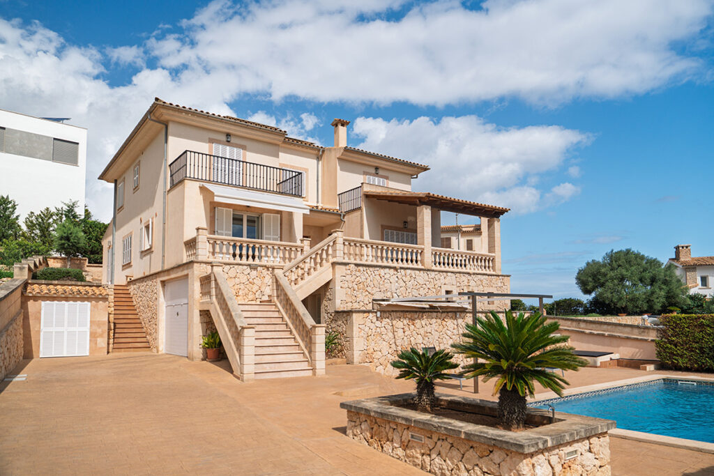 Villa con fachada de piedra, terrazas y piscina