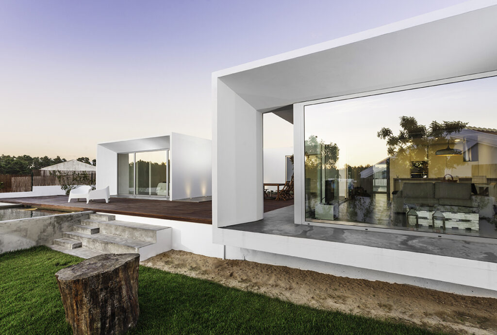 Arquitectura blanca con grandes ventanales y terraza